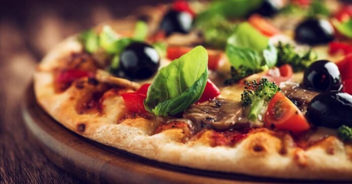 Healthy pizza with ham, broccoli, cherry tomatoes, red pepper an