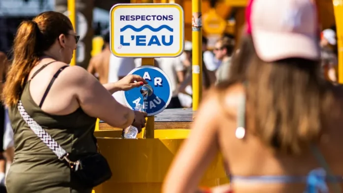 Festival-goers refill water bottles under the scorching sun at Les Déferlantes festival in France amid Europe’s ongoing record-breaking heatwave
