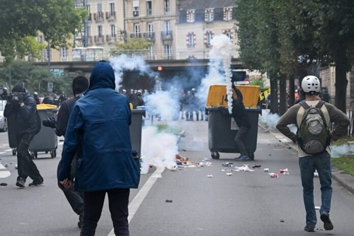 Protesters march through Paris holding union banners, demanding justice and opposing austerity measures in France’s contested draft 2026 budget