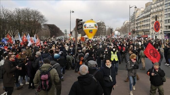 Striking teachers carry banners and union flags while marching through central Paris demanding cancellation of nationwide education job cuts